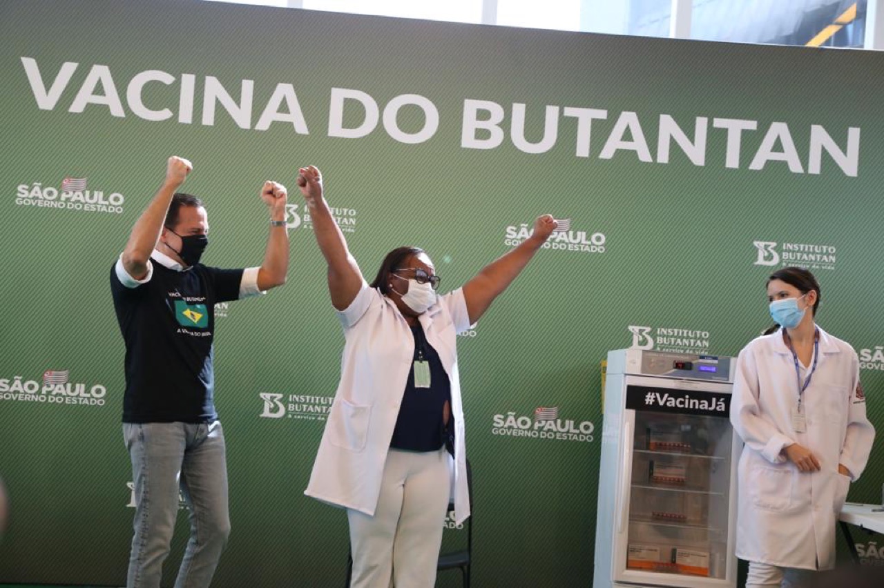 Mônica Calazans e outros presentes levantam os braços após a primeira dose aplicada no Brasil, em 17/01/2021.